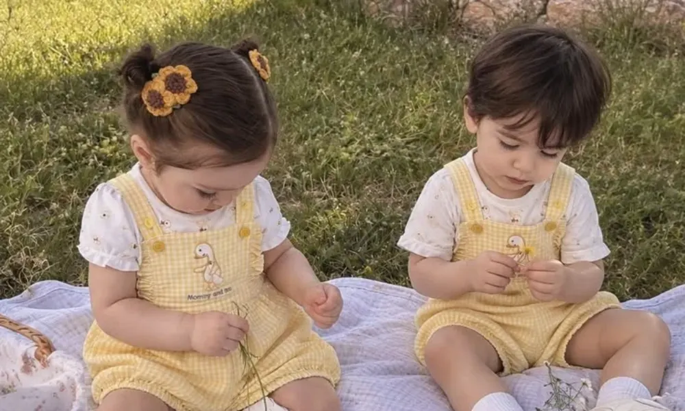  Cute toddler boy and girl playing on a blanket, featured in a guide on unisex names. 