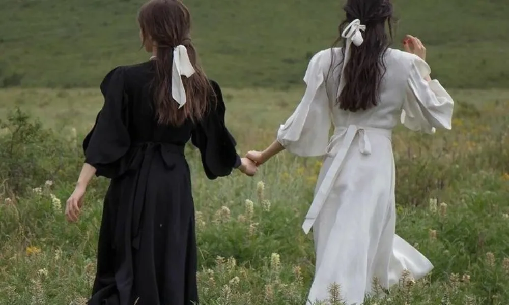 Aesthetic photo of best friends walking outdoors in a meadow for Cute Nicknames for Your Best Friend.