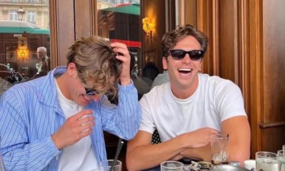Male best friends laughing at outdoor cafe for Funny Names for Your Best Friend. 
