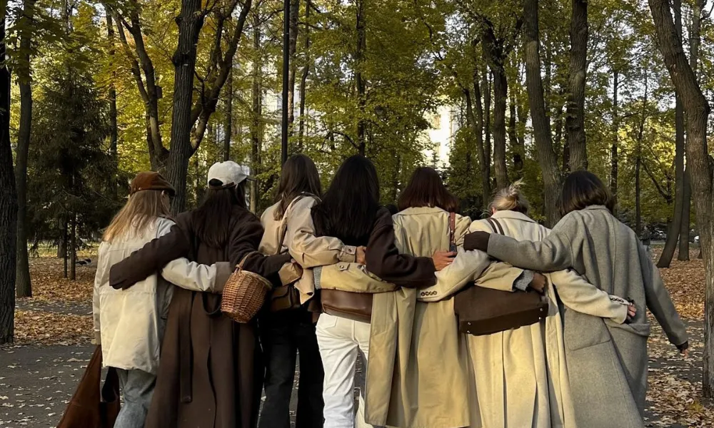 Best friends walking together in an autumn park for Funny Names for Group Chats.